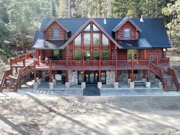 Two-story log home wall framing under construction overlooking a mountain valley