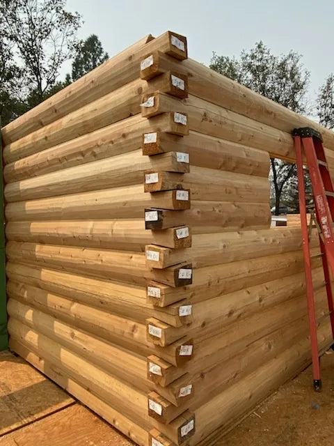 Close-up of interlocking log corner notches on a partially built log wall