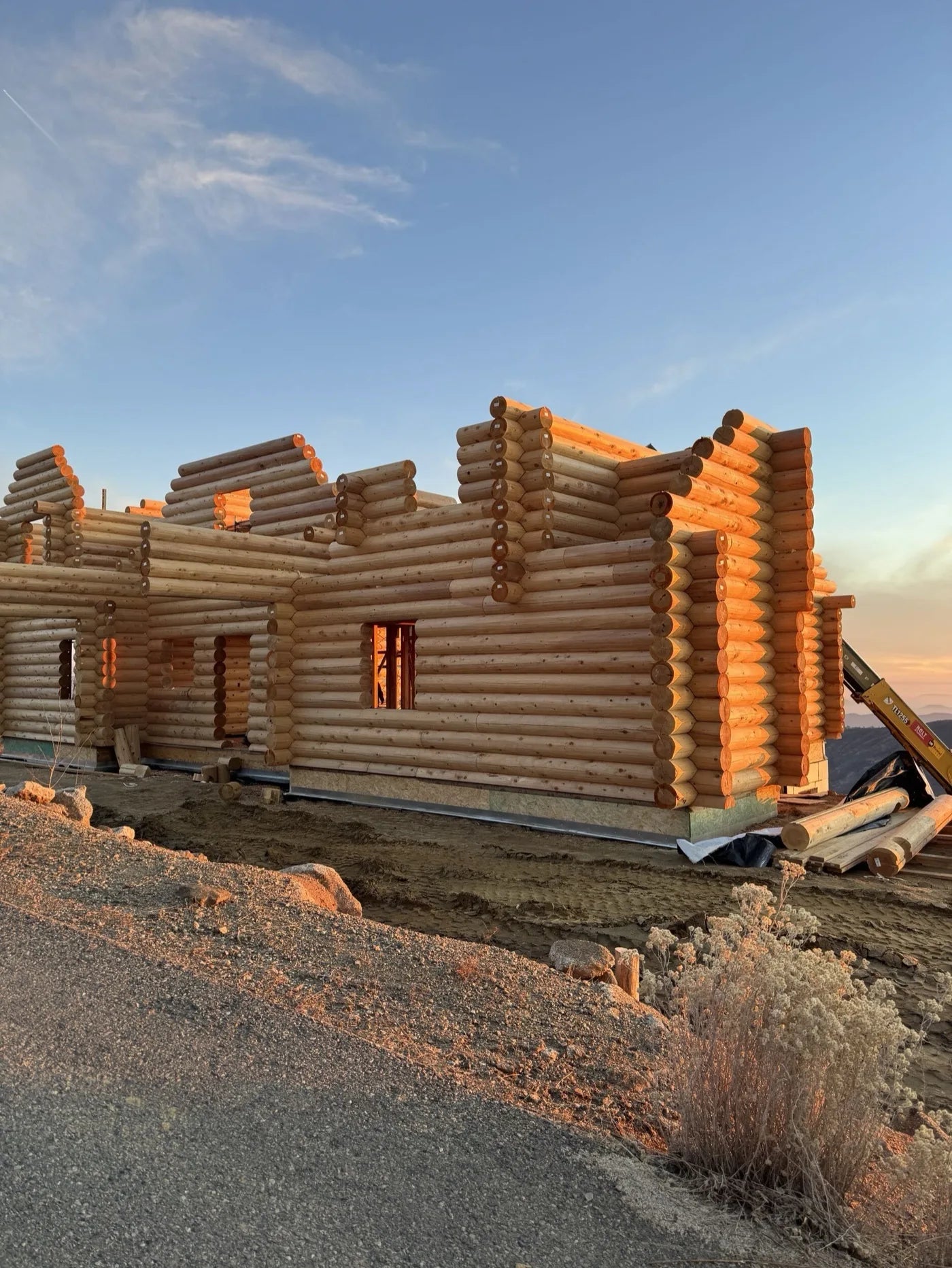 Log wall corners catching warm sunset light during construction