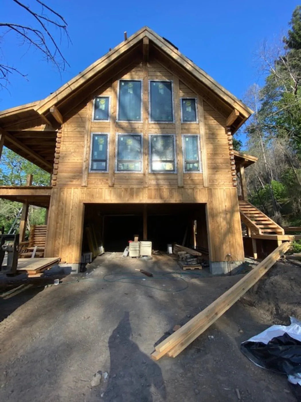 Aerial view of a framed subfloor with construction materials staged for a log build