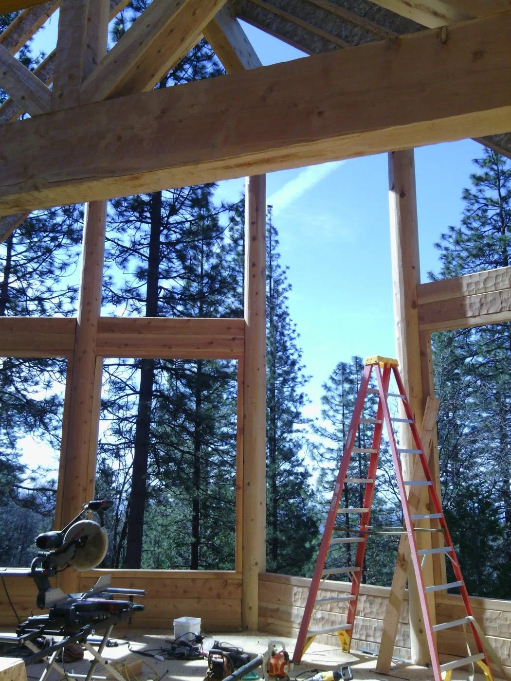 Finished log home front exterior with stone chimney and covered porch