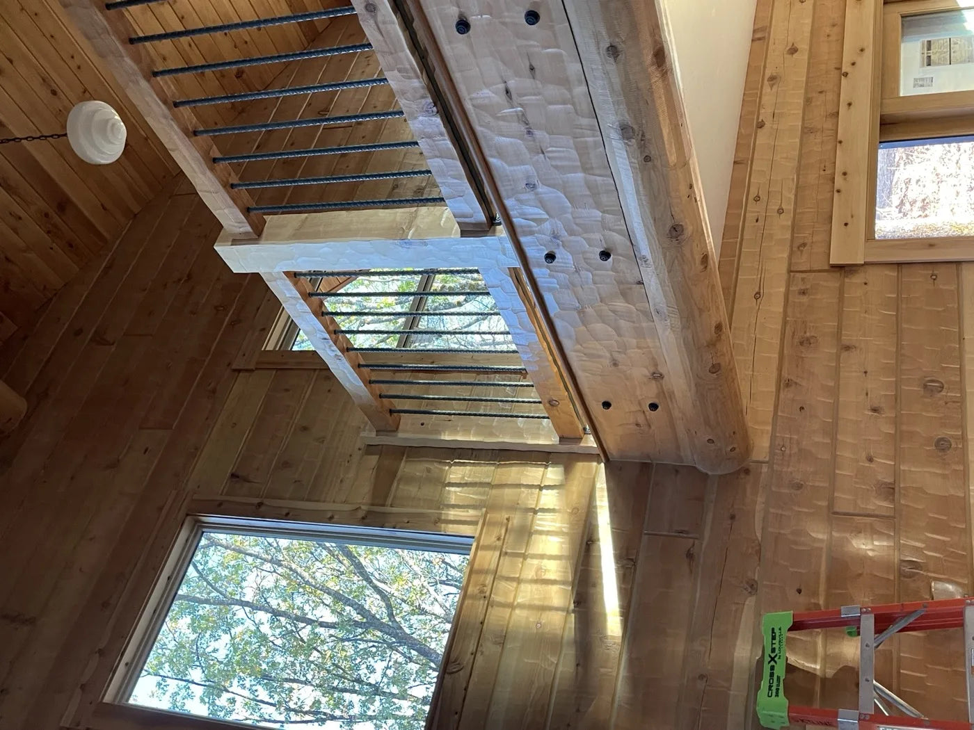 Interior loft railing with iron balusters overlooking the great room below