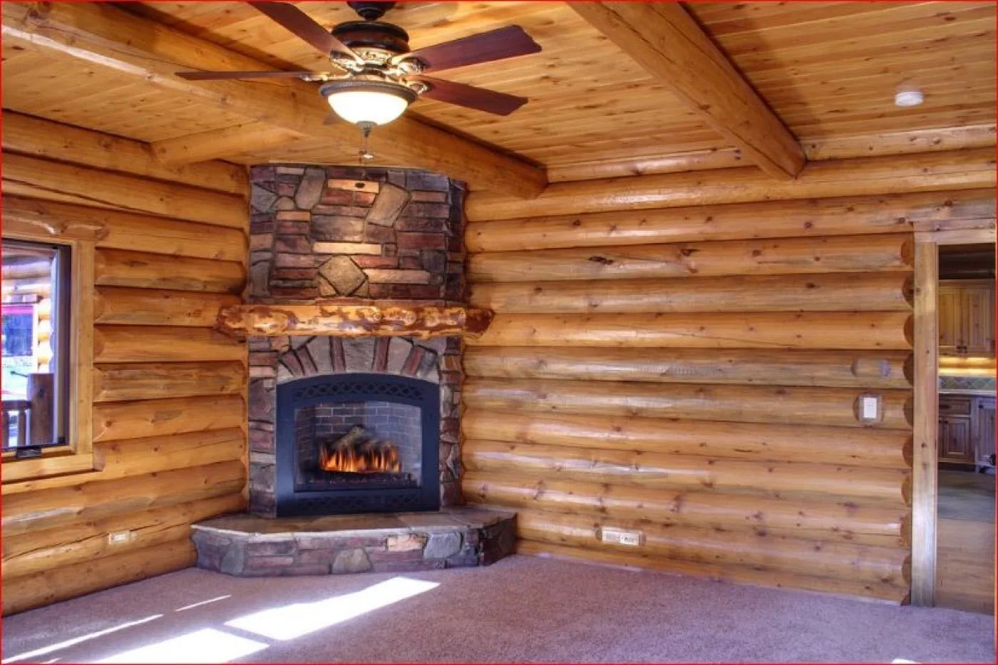 Corner stone fireplace with a wood mantel in a log home living room