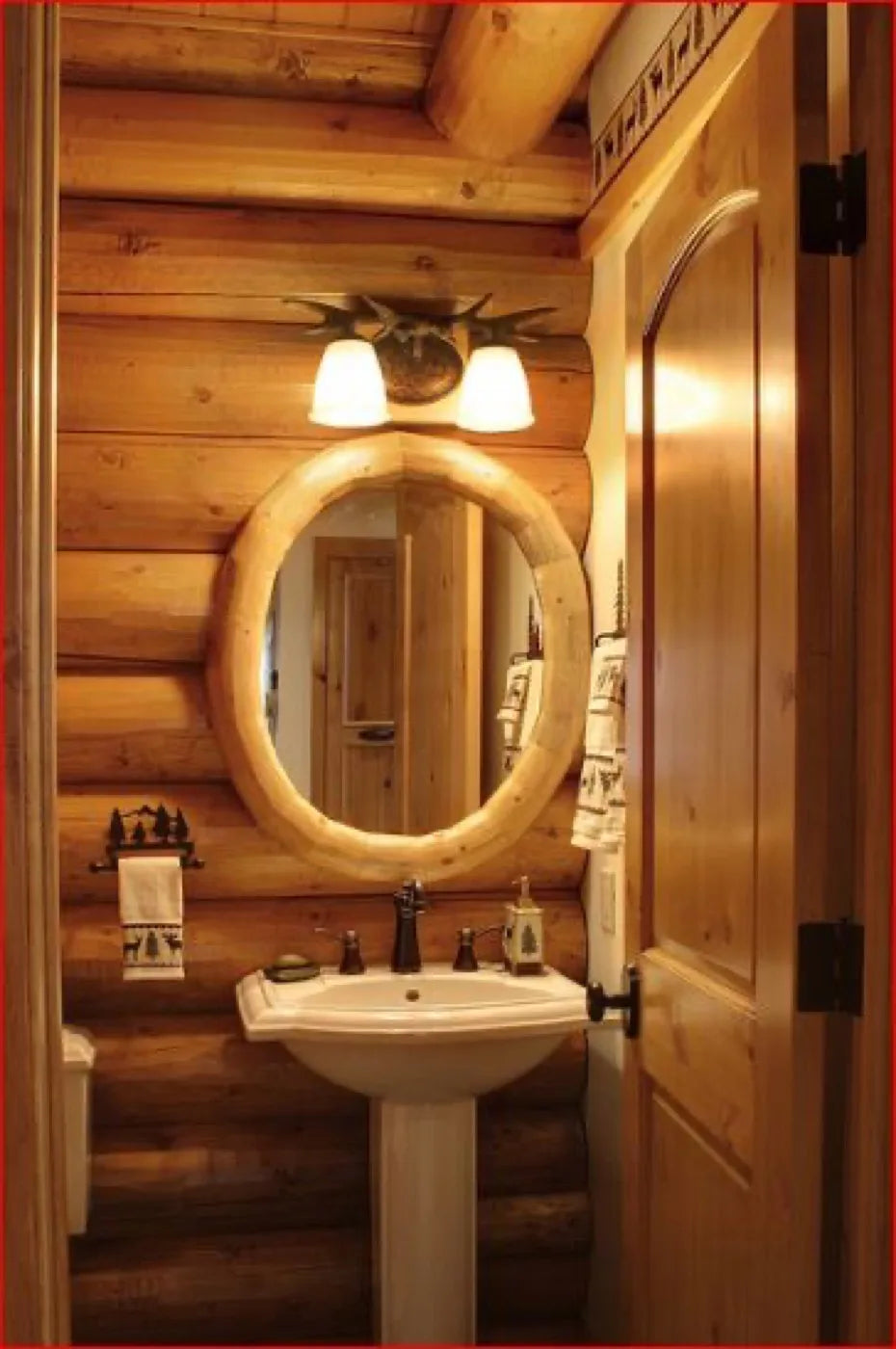 Log home half-bath with a pedestal sink and a round log-framed mirror