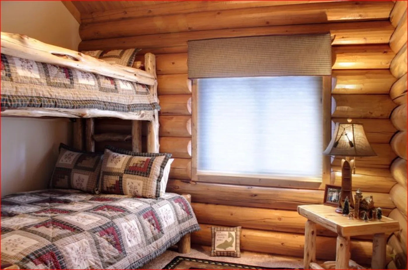 Log home bunk room with quilted bedding and a cellular window shade