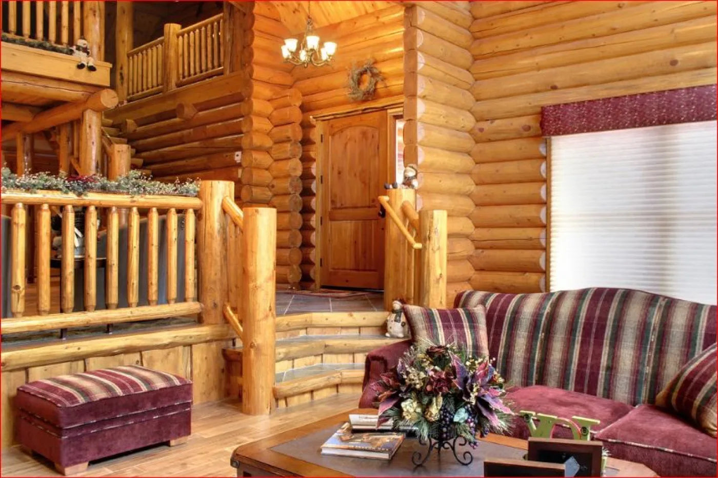 Log home entryway with a spiral staircase to the loft and a striped sectional sofa