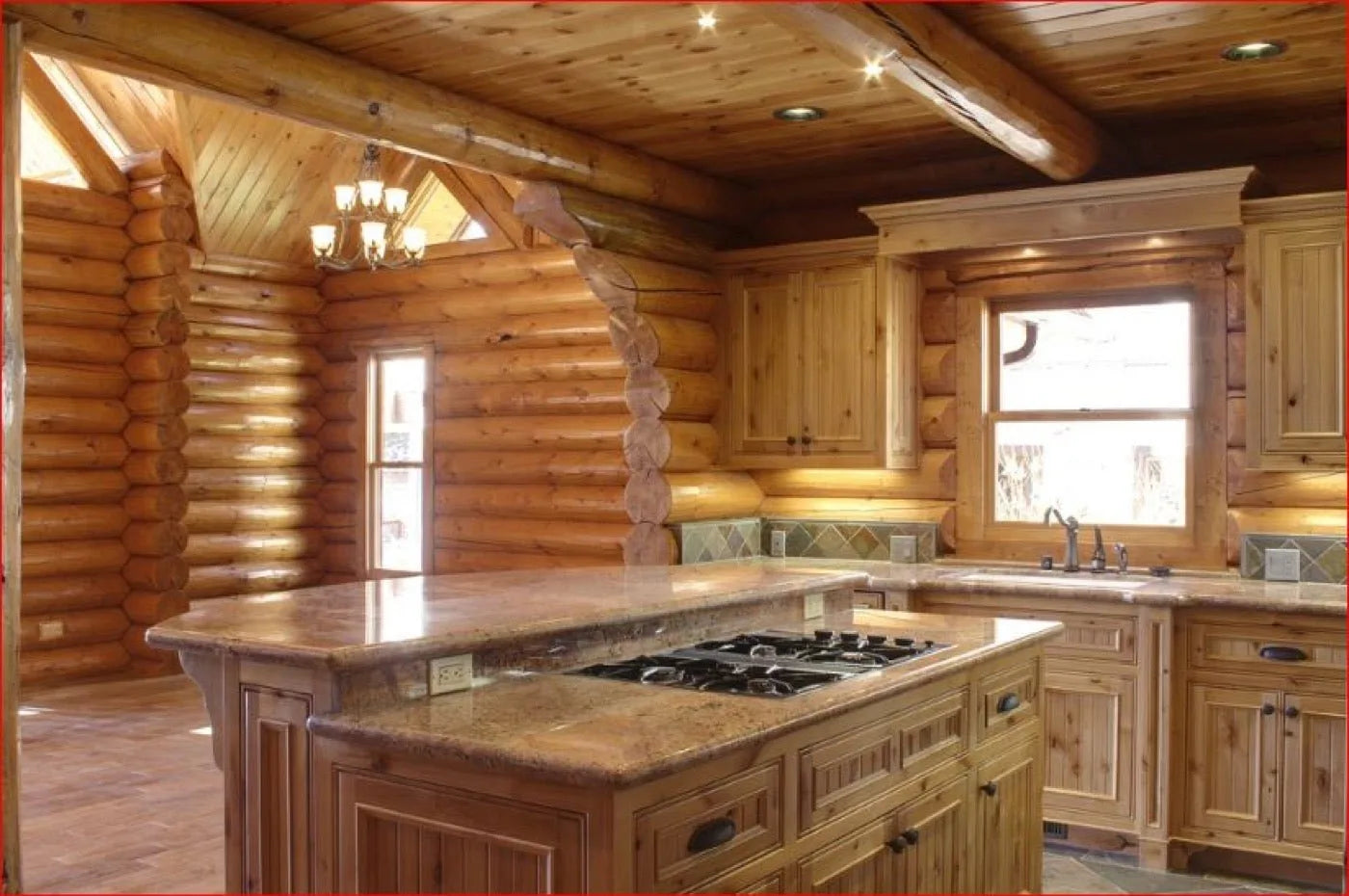 Log home kitchen with a vaulted ceiling, granite island cooktop, and pendant chandelier