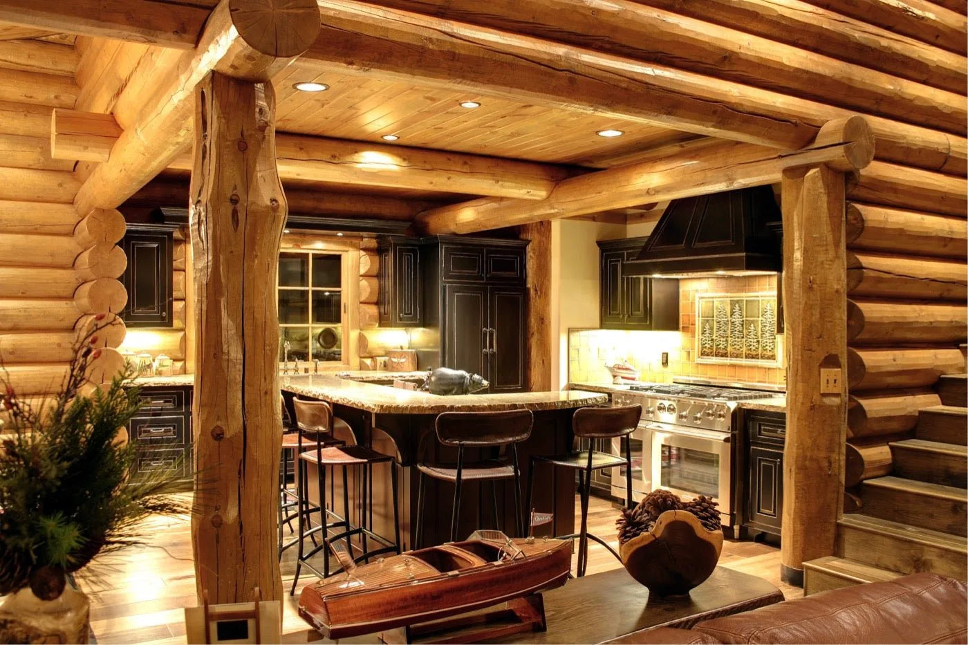 Log home kitchen with dark cabinetry, a granite bar, and a stainless range hood